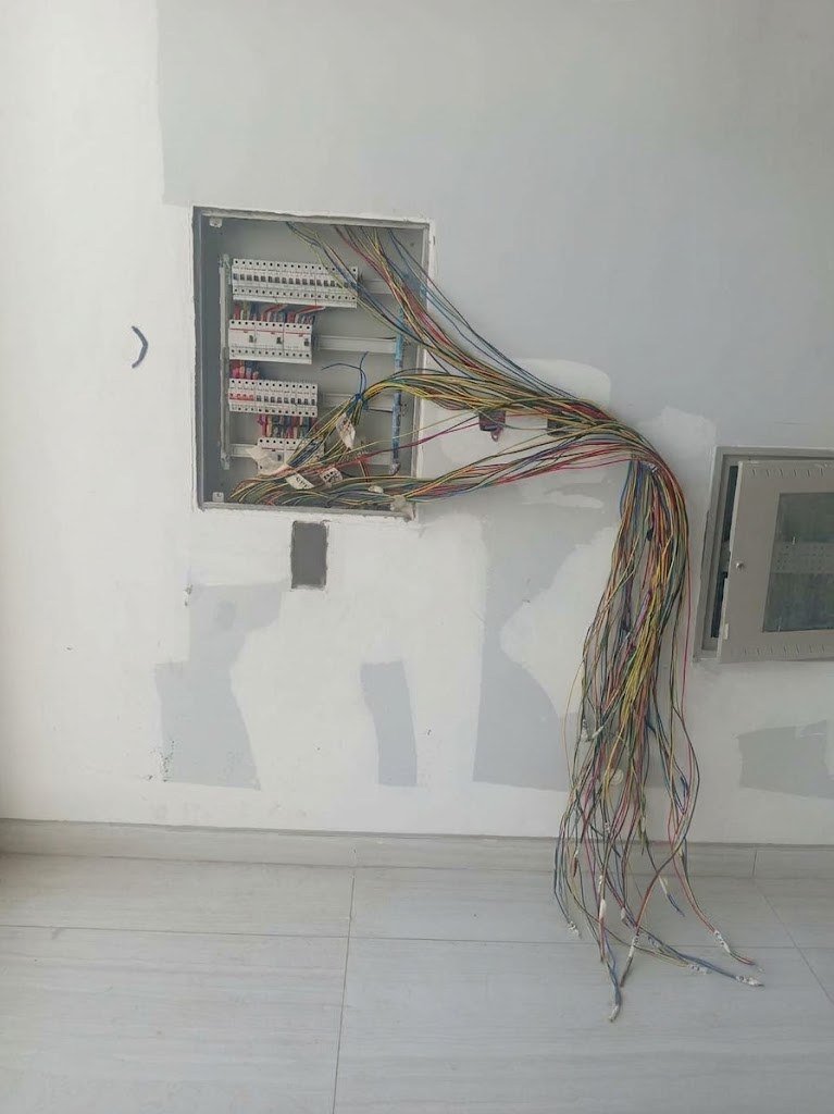 Distribution board with colour-coded cables during villa electrical works