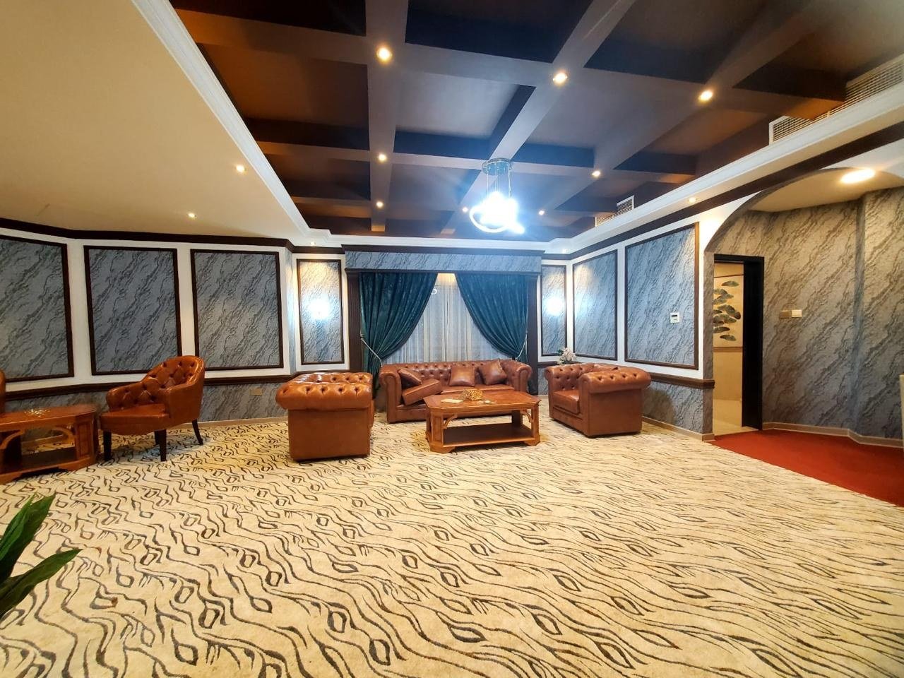 Finished villa lounge with a coffered ceiling, downlights and framed wall panels